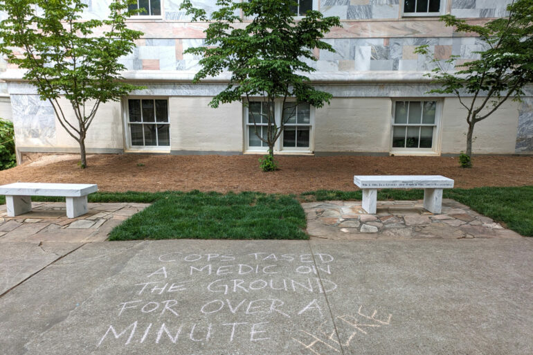 Image of graffiti near Emory Quadrangle saying, cops tased a medic on the ground for over a minute here.